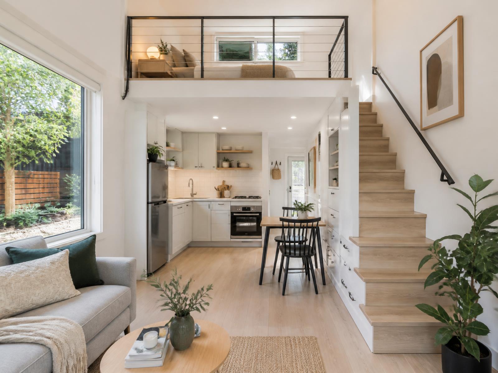 Bright laneway suite interior with kitchenette, dining area and loft bedroom